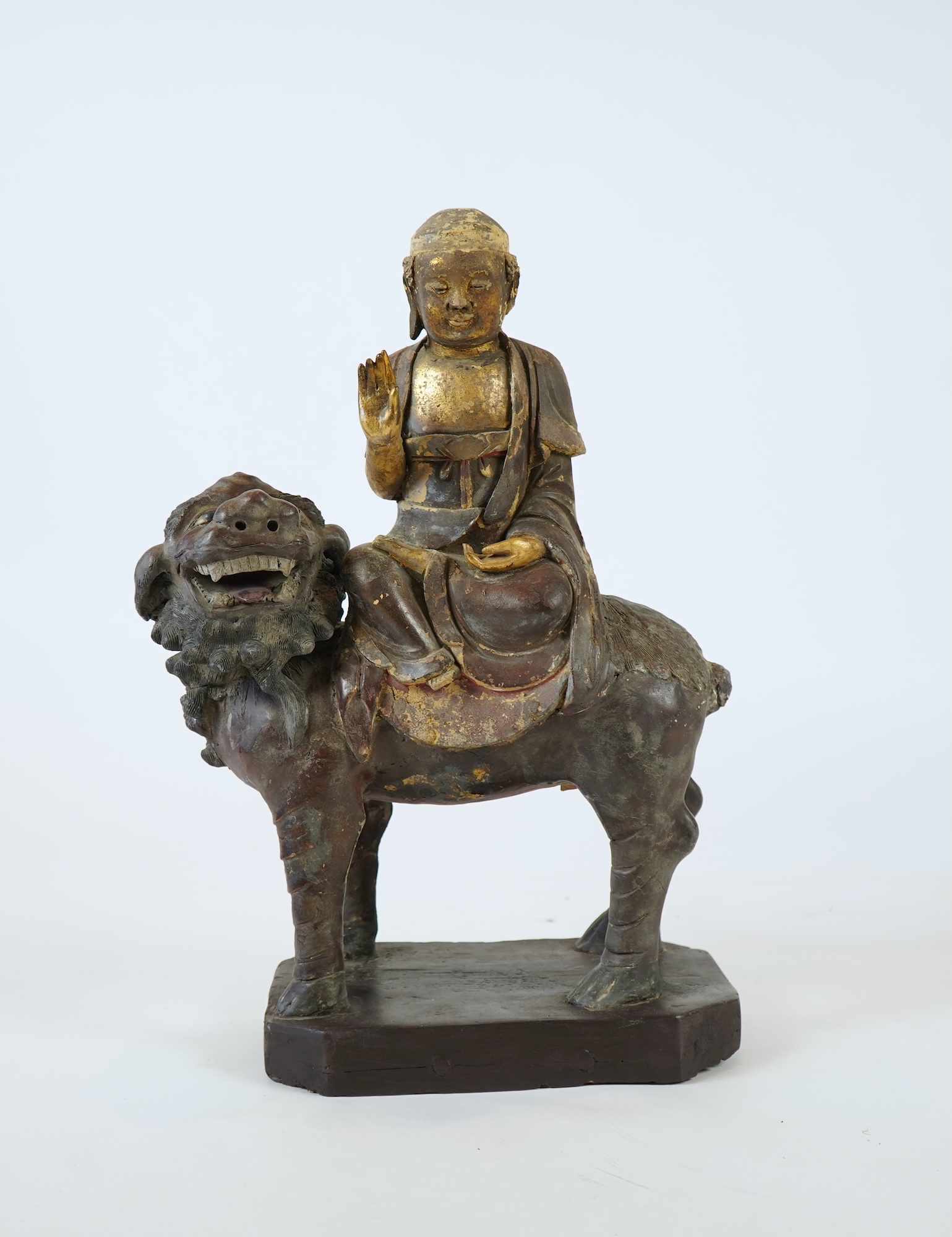 A Chinese gilt and polychrome lacquered stucco work and wood figure of Manjushri on a lion, Yuan-Ming dynasty
